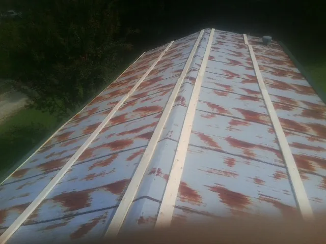Rusted metal roof panels with new wood purlins before replacement — Storm Damage Roof Repair in Southfields by Roofing Brothers